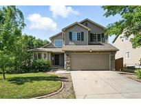 Charming two-story home featuring a well-manicured lawn, a two-car garage and stone accents at 22501 E Belleview Pl, Aurora, CO 80015