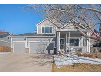 Two-story house with gray siding, attached garage, and front porch at 5907 E Tabor Pl, Castle Rock, CO 80104