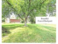 A beautifully landscaped backyard featuring mature trees and ample green space for outdoor activities at 8030 Ogden St, Denver, CO 80229