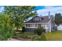 Charming two-story home featuring a mature front yard and covered porch in a well-maintained neighborhood at 4501 Zenobia St, Denver, CO 80212