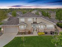 Charming two-story home featuring a well-manicured lawn, stone accents, and an attached two-car garage at 22342 E Plymouth Cir, Aurora, CO 80016