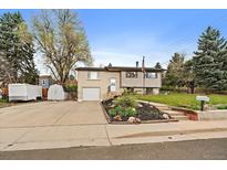 Charming split-level home features a well-manicured lawn, flower beds, and an attached one-car garage at 31 Circle Dr, Castle Rock, CO 80104