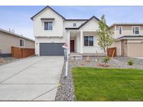 Charming two-story home with a well-manicured lawn and inviting front porch at 45940 Gentry Ave, Bennett, CO 80102