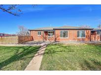 Charming brick home with a well-maintained front yard and inviting walkway under a clear, blue sky at 3200 Locust St, Denver, CO 80207