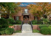 Inviting brick home with manicured landscaping, a balcony, and a gated entrance at 445 Madison N St, Denver, CO 80206