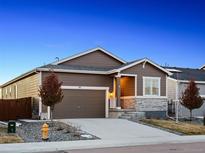 Charming single-Gathering home with a two-car garage, manicured lawn, and stone accents under a picturesque twilight sky at 55 S Edge Cliff St, Castle Rock, CO 80104