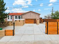 Inviting home with a modern garage door, gated driveway, and charming curb appeal at 3595 W 67Th S Ave, Denver, CO 80221