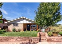 Charming brick ranch-style home with a well-manicured lawn and a beautiful mature tree at 4585 Hooker St, Denver, CO 80211