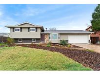 Two story home featuring stone accents, a two car garage and partially grass front yard at 7333 S Dexter Way, Centennial, CO 80122