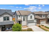 Charming two-story home with a light gray exterior, a two-car garage, and professional landscaping at 19131 E 65Th Ave, Denver, CO 80249