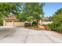 Inviting home featuring a red tile roof, mature landscaping, and an attached two-car garage at 5480 S Holly St, Greenwood Village, CO 80111