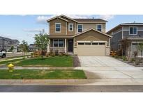 Two-story home featuring a two car garage, front porch and nicely manicured lawn at 24707 E 40Th Ave, Aurora, CO 80019