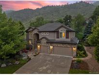 Stunning two-story home with a stone facade and a three-car garage, nestled against a scenic mountain backdrop at 19061 Eagle Ridge Dr, Golden, CO 80401