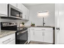 Bright kitchen features stainless steel appliances, granite countertops, and subway tile backsplash at 2835 S Monaco Pkwy # 4-103, Denver, CO 80222