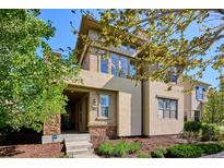 Tan two-story home with stone accents and a landscaped front yard at 9167 E 35Th Ave, Denver, CO 80238