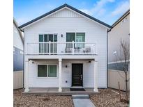 Charming two-story home featuring a quaint balcony and a well-maintained front yard with rock landscaping at 13585 E 103Rd Pl, Commerce City, CO 80022