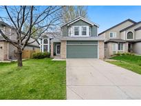 Charming two-story home with a well-manicured lawn and a two-car garage is bathed in sunlight at 1474 E Weldona Way, Superior, CO 80027
