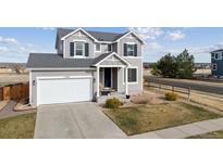 Charming two-story home featuring a well-kept lawn and a two-car garage, freshly painted in neutral gray with blue shutters at 11594 Yellow Daisy Dr, Parker, CO 80134