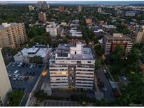 Aerial view of a condominium building with parking and the city in the background at 740 N Pearl St # 606, Denver, CO 80203