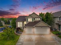 Beautiful two-story home with a three-car garage and well-manicured landscaping at sunset at 22428 Quail Run Ln, Parker, CO 80138