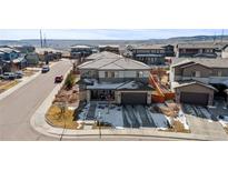Two-story home with gray siding, stone accents, a dark roof and attached two car garage at 14100 Blue Wing Ln, Parker, CO 80134