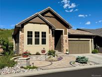 Charming single-Gathering home boasts stone accents, a tile roof, and a well-manicured front yard with mature landscaping at 6268 Dakota Ridge Dr, Littleton, CO 80125