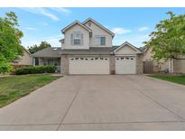 Charming two-story home with a large driveway and a three car garage, set against a blue sky at 2246 S Ensenada St, Aurora, CO 80013