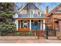 Charming blue two-story home with covered porch, white columns, and well-kept landscaping at 91 S Sherman St, Denver, CO 80209
