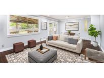 Bright living room featuring modern decor, a comfortable sofa, and a large window providing natural light at 760 Dean Dr, Northglenn, CO 80233