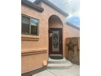 Arched front door with decorative glass and brown trim, complemented by decorative star on adjacent fence at 11610 Hooker St, Westminster, CO 80031