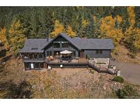 Aerial view of the mountain home showing its extensive deck, large windows, and natural surroundings at 239 Aspen Pl, Evergreen, CO 80439