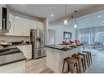 Modern kitchen features stainless steel appliances and an island with seating at 14936 E Hampden Ave # 202, Aurora, CO 80014