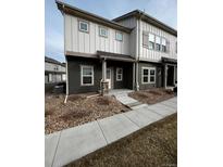 Two-story townhouse featuring neutral siding, stone accents and tidy front yard landscaping at 899 Winding Brook Dr, Berthoud, CO 80513