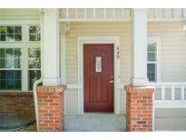 Charming home featuring a deep red front door framed by brick and white columns at 640 S Yarrow St, Lakewood, CO 80226