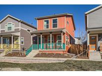 Charming two-story home featuring a cozy porch, colorful accents, and well-maintained landscaping at 10331 E 62Nd Pl, Denver, CO 80238