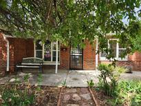 Charming red brick home featuring a lovely front porch and a decorative brick walkway at 938 Salem St, Aurora, CO 80011