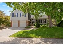 Charming two-story home with well-manicured lawn, mature trees, and a two car garage at 5808 E Hinsdale Pl, Centennial, CO 80112