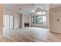 Bright living room boasts a fireplace, large window, and vaulted ceilings, creating a welcoming atmosphere at 2847 Mount Royal Dr, Castle Rock, CO 80104