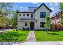 Charming two-story home with a bright white exterior, dark accents, a manicured lawn, and a stone walkway at 1195 S Milwaukee St, Denver, CO 80210