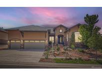 Charming single-Gathering home featuring a stone and stucco facade, three-car garage, and a well-manicured front yard at 15637 Deer Mountain Cir, Broomfield, CO 80023