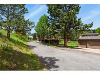 Scenic view of home's driveway, two car detached garage and a cozy deck at 30221 Stagecoach Blvd, Evergreen, CO 80439