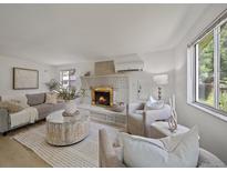 Bright living room featuring a brick fireplace, plush seating, and natural light at 1018 Kelly Pl, Longmont, CO 80501