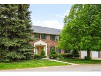 Charming two-story brick home with a well-maintained lawn and mature trees at 4398 W Lake S Cir, Littleton, CO 80123