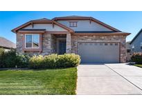 Charming single-Gathering home featuring a stone facade, two-car garage, and well-maintained landscaping at 12340 Syracuse St, Thornton, CO 80602
