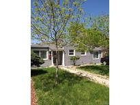 Charming single-story home with gray siding, a well-manicured lawn, and a welcoming walkway at 1925 Joliet St, Aurora, CO 80010