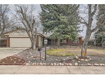 Inviting single-story brick home with a manicured front yard and mature trees at 2056 S Newark Way, Aurora, CO 80014
