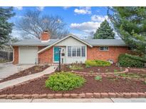 Charming brick home with a well-manicured front yard and a bright blue front door at 3335 S Verbena Ct, Denver, CO 80231
