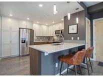 Modern kitchen boasts stainless steel appliances, white cabinets, and a breakfast bar with seating at 1316 Snowberry Ln # 101, Louisville, CO 80027