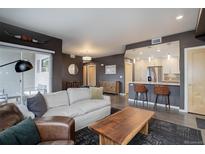 Cozy living room featuring modern furnishings, dark accent walls, and an open layout connecting to the kitchen at 1316 Snowberry Ln # 101, Louisville, CO 80027