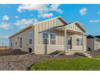 Inviting single story home with neutral siding, manicured front lawn, and lovely covered front porch and entryway at 2997 Pershing St, Strasburg, CO 80136